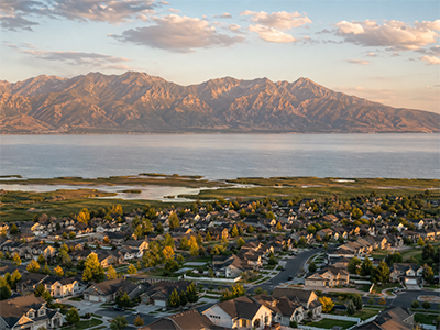 Saratoga Springs from above at golden hour with Utah Lake and the Wasatch Mountains in the distance